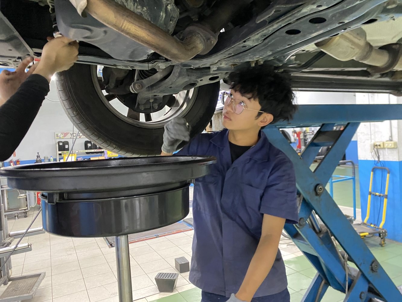 學生在舉升車輛下方作業
